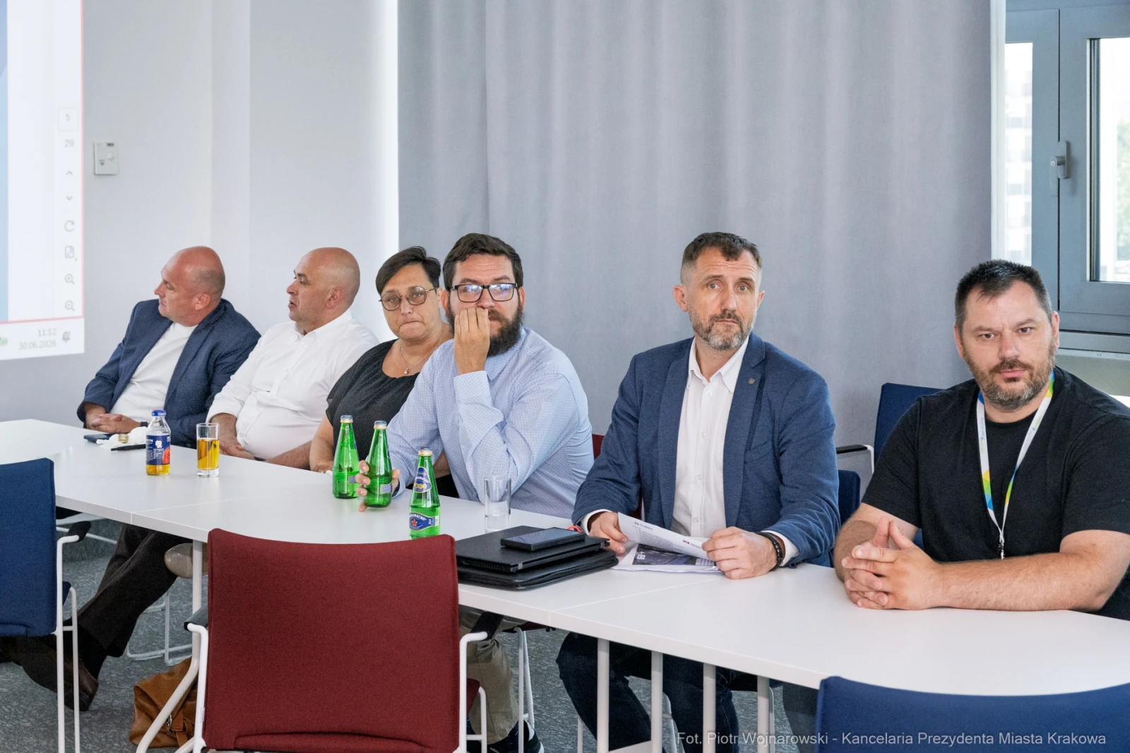 Grupa mężczyzn i kobiet siedzących przy stole, z napojami na stole.  Autor: Piotr Wojnarowski