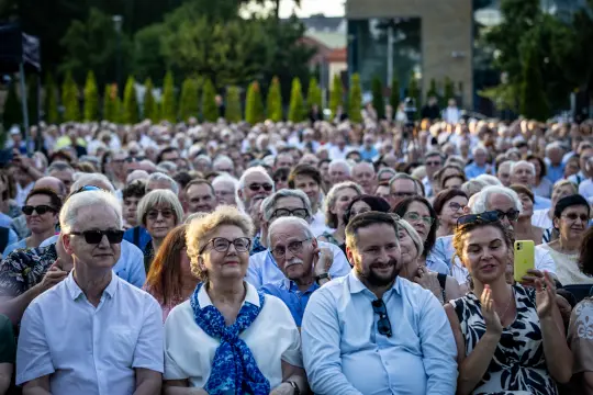 Tłum ludzi na wydarzeniu, niektórzy klaskają, różnorodne reakcje i emocje.