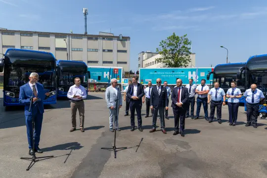 Konferencja prasowa z udziałem przedstawicieli władz i pracowników, obok nowych autobusów.