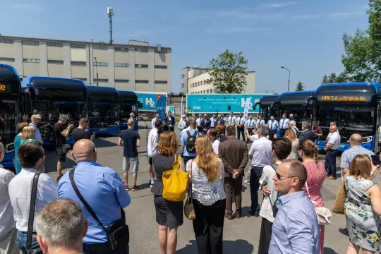 Uroczystość z udziałem ludzi i nowych autobusów w Krakowie.