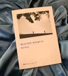 Okładka książki Wojciecha Bonowicza "Bardzo" na tle niebieskiego materiału.