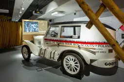 Samochód z lat 30. XX wieku, wystawiony w muzeum, z informacjami o podróży dookoła świata.