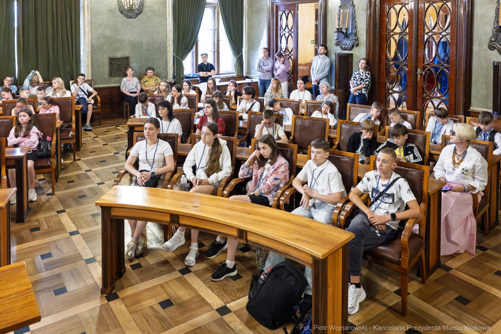 Grupa młodzieży siedząca w sali obrad, uczestnicząca w spotkaniu.  Autor: Piotr Wojnarowski