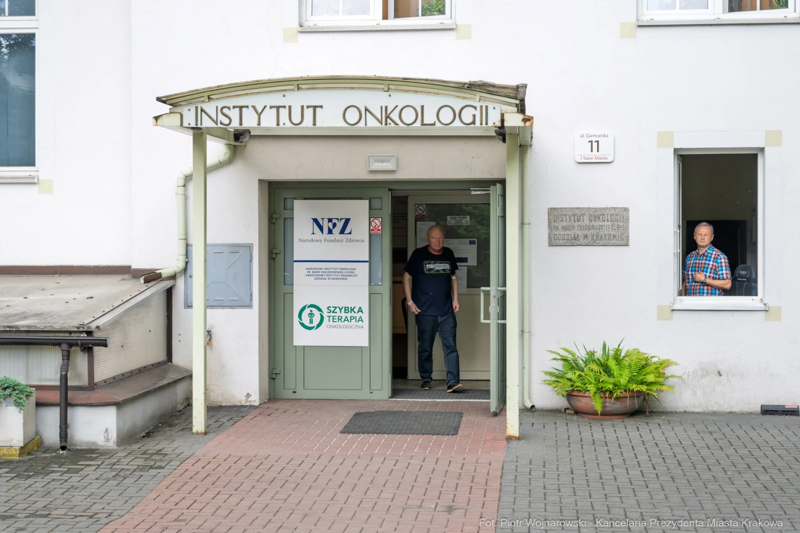 Instytut Onkologii z wejściem i osobami w drzwiach.  Autor: Piotr Wojnarowski