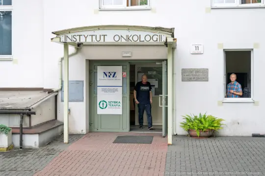 Instytut Onkologii z wejściem i osobami w drzwiach.