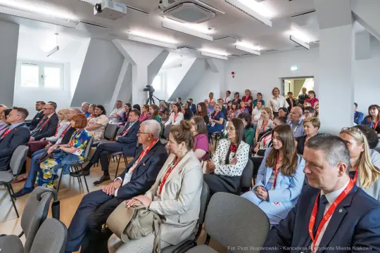 Zgromadzenie uczestników konferencji w sali wykładowej.