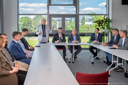 Spotkanie grupy mężczyzn przy stole w sali konferencyjnej.