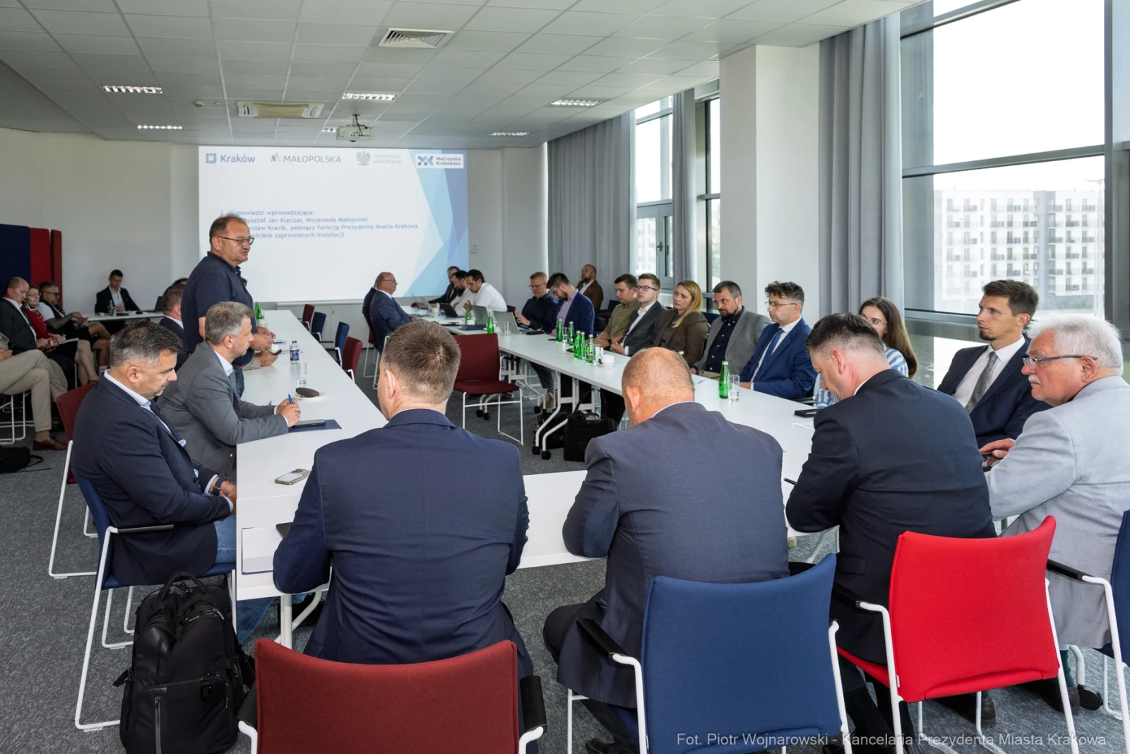 Spotkanie biznesowe z uczestnikami przy długim stole w nowoczesnej sali konferencyjnej.  Autor: Piotr Wojnarowski