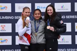 Trzy zawodniczki na podium z medalami w zawodach wspinaczkowych.