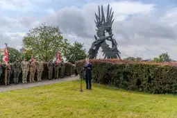 Ceremonia z udziałem żołnierzy i mówcy przy pomniku.