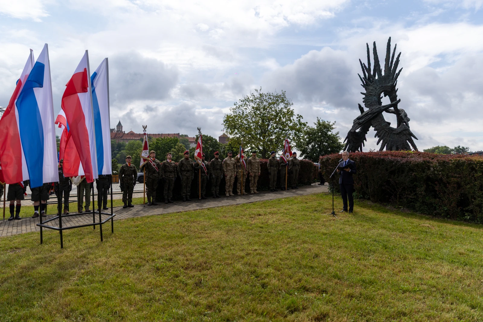 Uroczystość z udziałem żołnierzy i flag, obok pomnika.  Autor: Bogusław Świerzowski