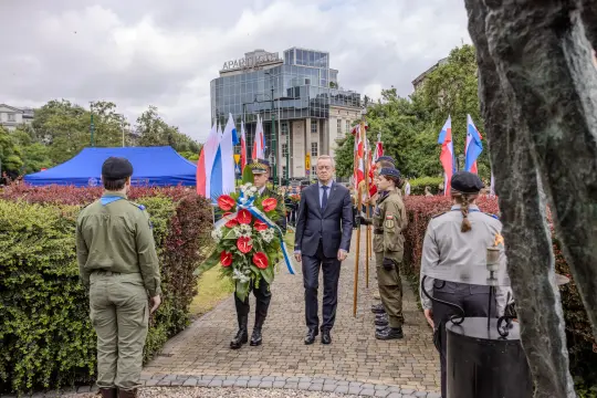 Uroczystość składania wieńca z udziałem żołnierzy i flag różnych krajów.