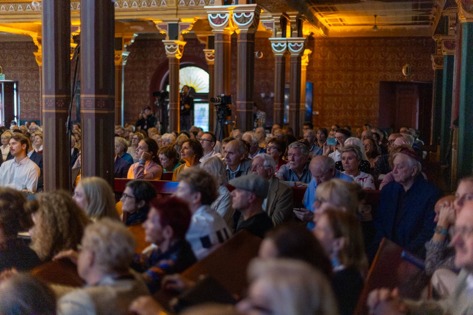Tłum ludzi na wydarzeniu kulturalnym, skupionych na wystąpieniu.  Autor: Bogusław Świerzowski