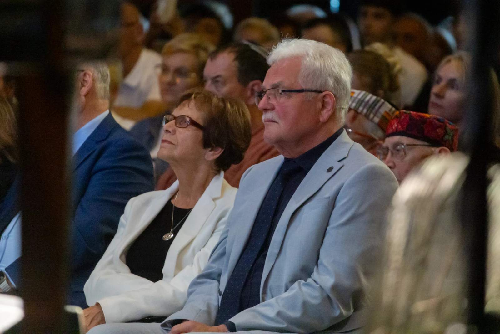 Grupa osób siedzących w tłumie, skupionych na wydarzeniu.  Autor: Bogusław Świerzowski