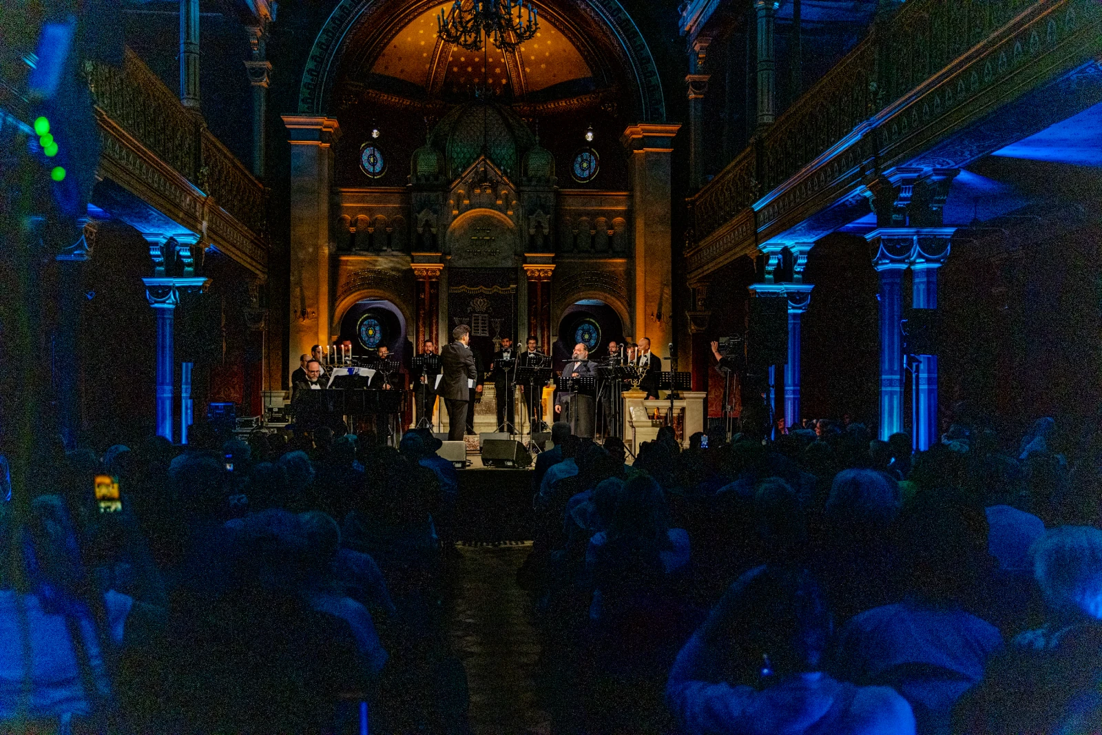 Koncert w zabytkowej sali, z chórem i orkiestrą, oświetlenie w niebieskich i pomarańczowych tonach.  Autor: Bogusław Świerzowski