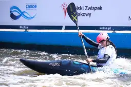 Kajakarka płynąca w nurcie rzeki, intensywnie wiosłująca w zawodach.
