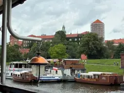 Widok na rzekę z łodzią i zabytkowymi budynkami w tle.