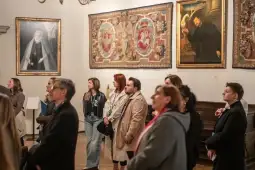 Grupa ludzi oglądająca wystawę sztuki w muzeum.