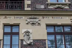 Napis na elewacji budynku z datą 1887 oraz nazwiskiem architekta Talowskiego.