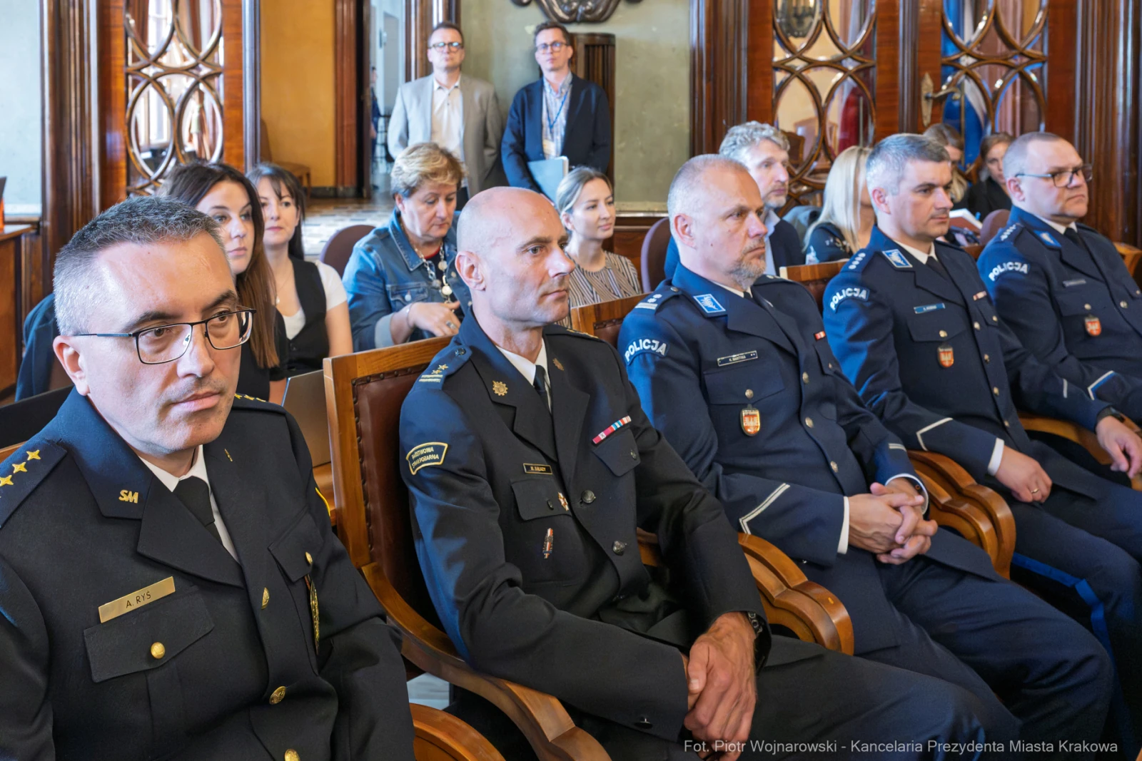 Uczestnicy ceremonii w sali, w tym przedstawiciele służb mundurowych.  Autor: Piotr Wojnarowski