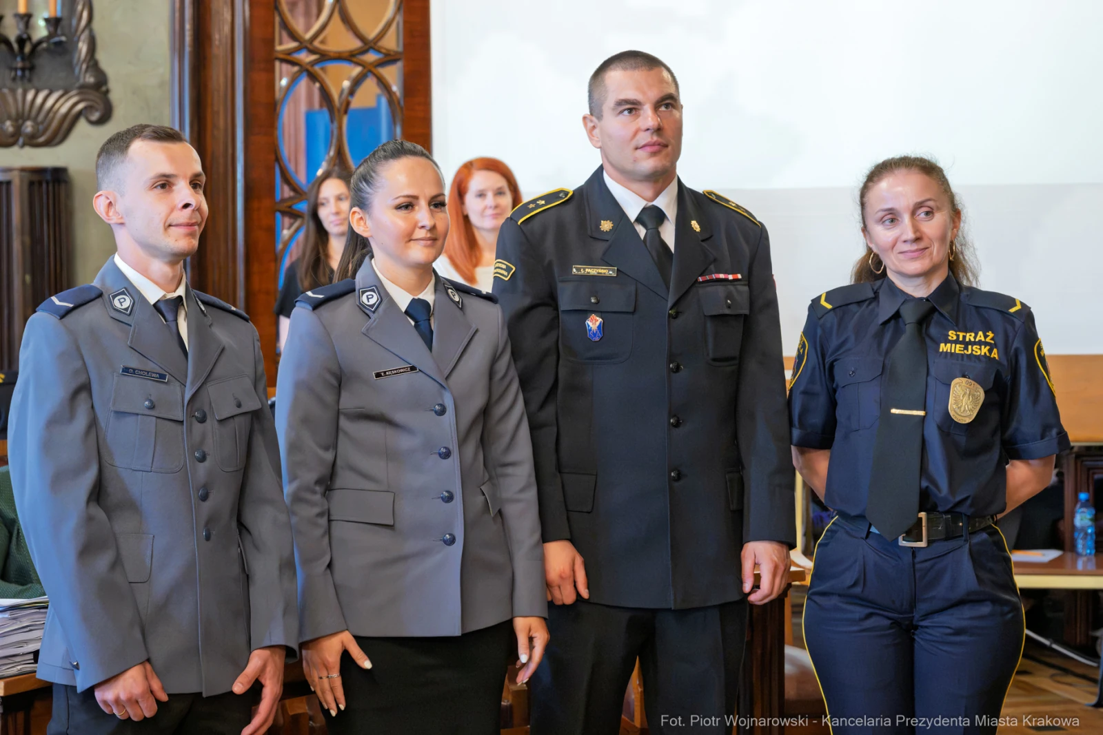 Cztery osoby w mundurach, w tym policjant i strażnik miejski, podczas uroczystości.  Autor: Piotr Wojnarowski