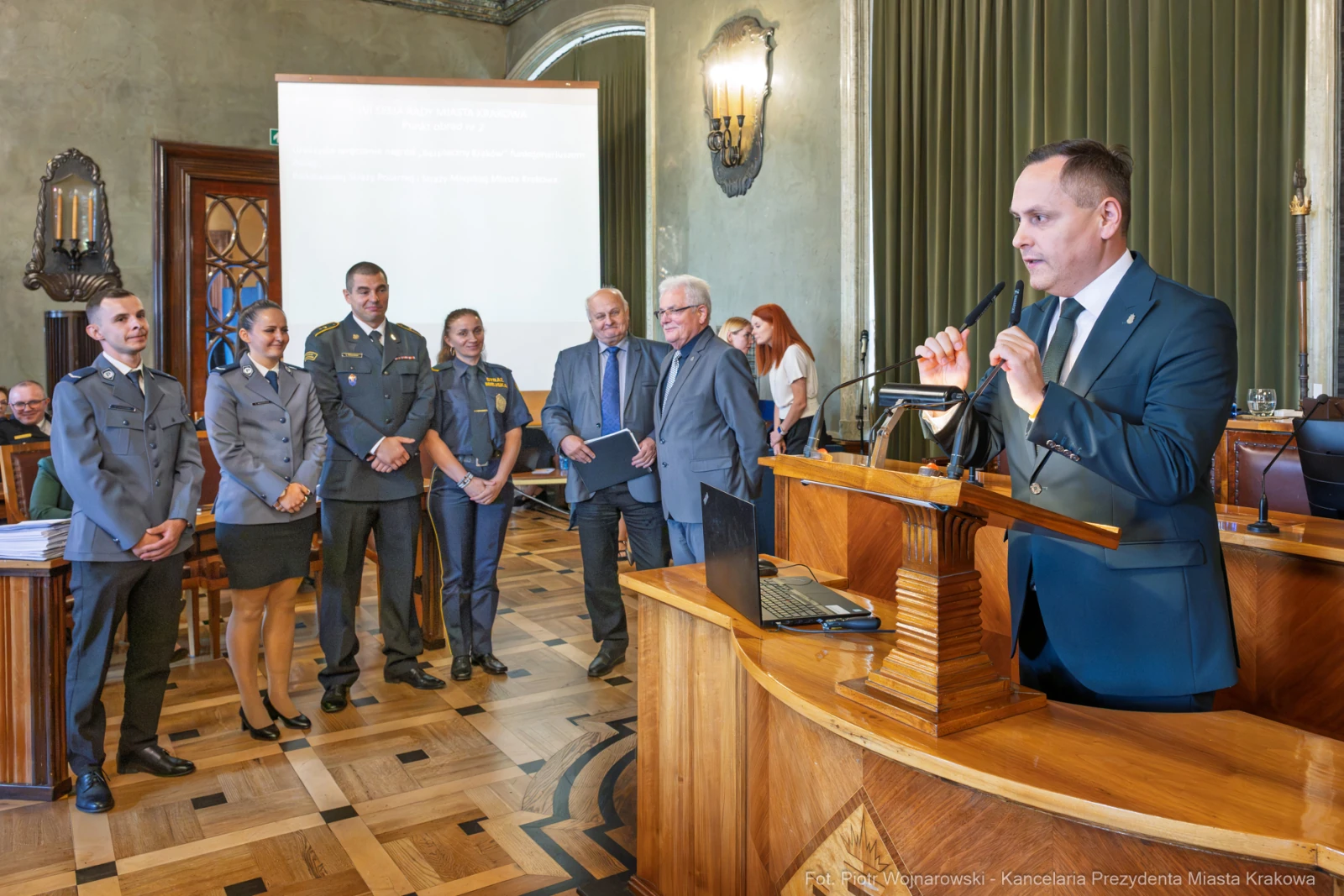 Uroczystość wręczenia nagród w sali obrad z uczestnikami w mundurach i mówcą przy mównicy.  Autor: Piotr Wojnarowski