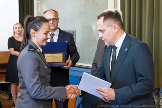 Uroczystość wręczenia nagrody, uściski dłoni, gratulacje.
