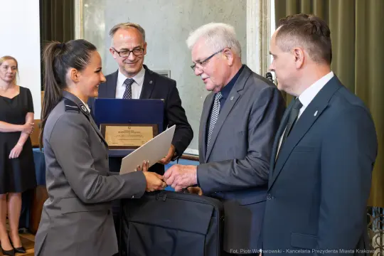 Uroczystość wręczenia nagrody, uściski dłoni i gratulacje.