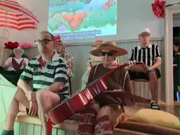 Grupa osób w strojach letnich, jedna gra na gitarze, w tle animacja.