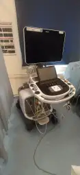 Ultrasonograf z monitorem i panelami sterującymi, używany w diagnostyce medycznej.