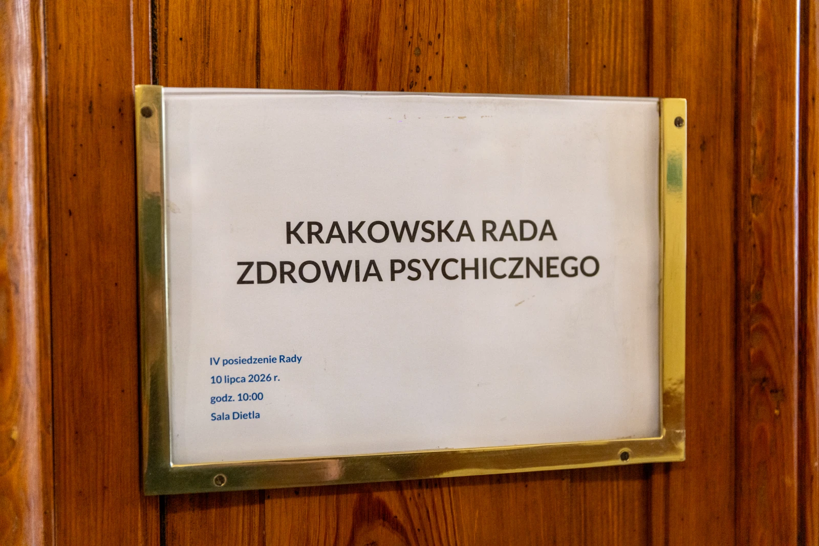 Tablica informacyjna Krakowskiej Rady Zdrowia Psychicznego z datą i godziną posiedzenia.  Autor: Bogusław Świerzowski
