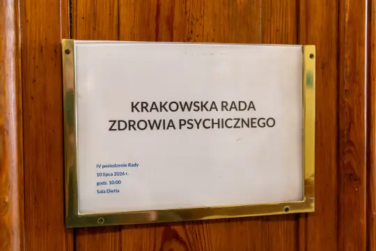 Tablica informacyjna Krakowskiej Rady Zdrowia Psychicznego z datą i godziną posiedzenia.