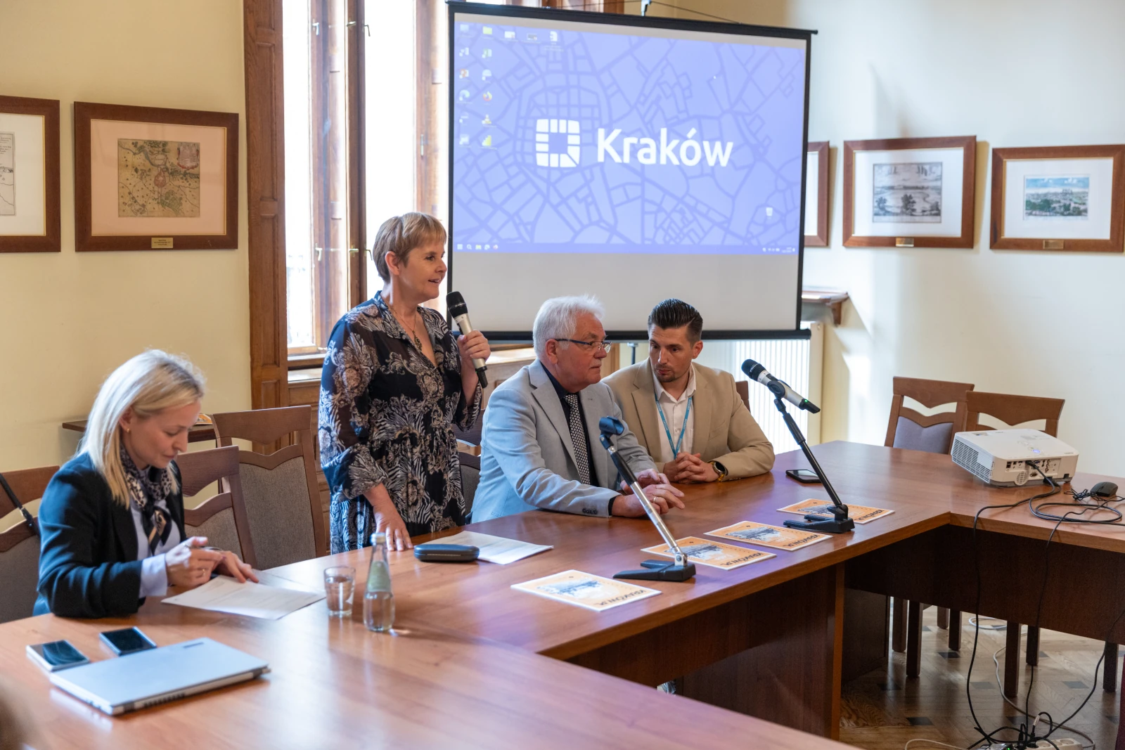 Konferencja w Krakowie, prelegenci przy stole, prezentacja na ekranie.  Autor: Bogusław Świerzowski