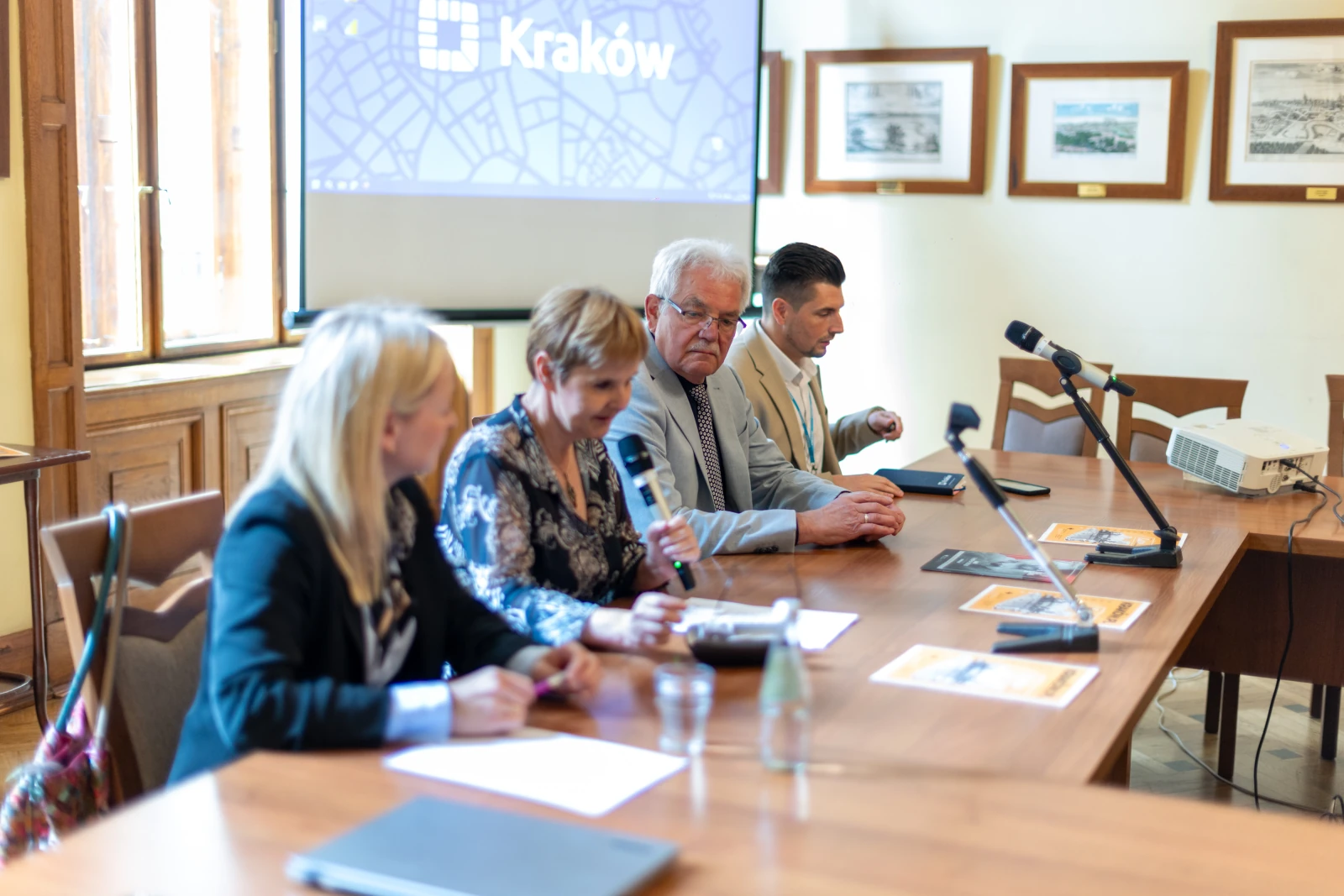 Konferencja w Krakowie z czterema prelegentami przy stole, prezentacja w tle.  Autor: Bogusław Świerzowski