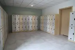 Pusty pokój z szafkami na ubrania w jasnych kolorach.