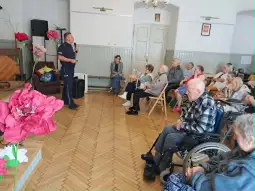 Spotkanie z seniorami, mężczyzna prowadzi wykład, uczestnicy słuchają w sali.