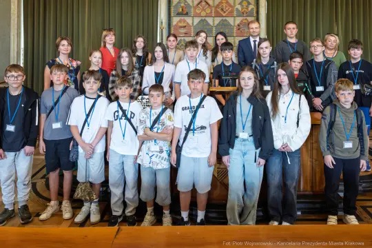 Grupa dzieci i młodzieży na tle sali, wszyscy w identyfikatorach.