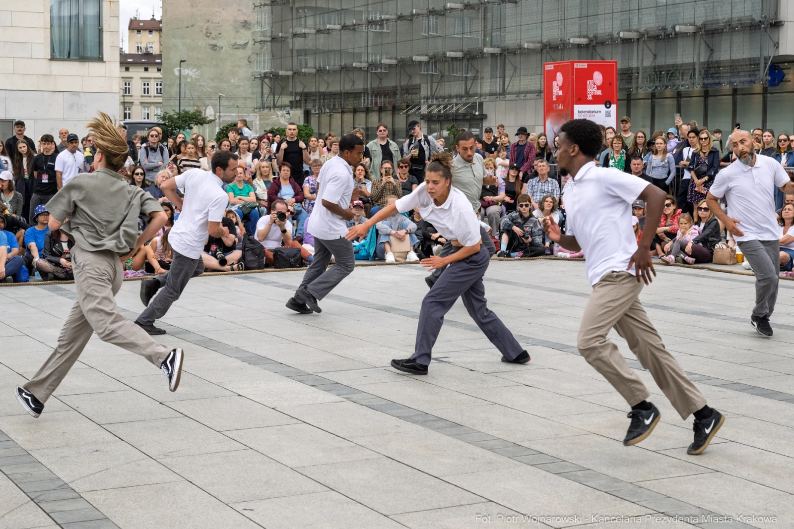 Grupa tancerzy wykonujących choreografię na placu, otoczona widownią.  Autor: Piotr Wojnarowski