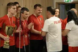 Zawodnicy w czerwonych koszulkach odbierają nagrody i medale po zawodach.
