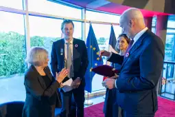Ceremonia wręczenia odznaczeń w obecności flagi Francji i Unii Europejskiej.