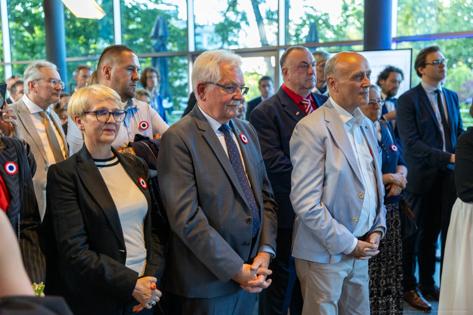 Grupa ludzi w eleganckich strojach, z przypinkami, uczestniczy w wydarzeniu.  Autor: Bogusław Świerzowski