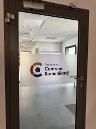 Drzwi do Regionalnego Centrum Komunikacji z logo i nazwą instytucji.