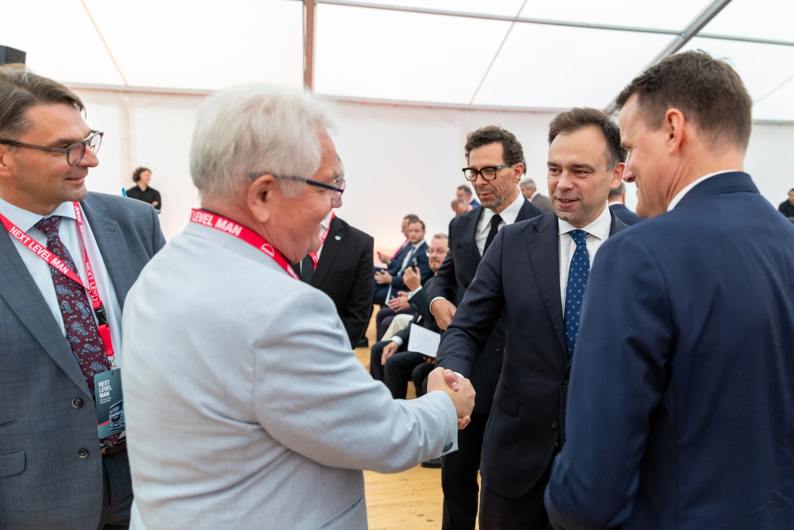 Spotkanie kilku mężczyzn w garniturach, wymiana uścisków dłoni.  Autor: Bogusław Świerzowski