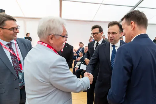 Spotkanie kilku mężczyzn w garniturach, wymiana uścisków dłoni.