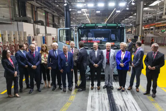 Grupa ludzi w fabryce przy pierwszym elektrycznym ciężarówce.