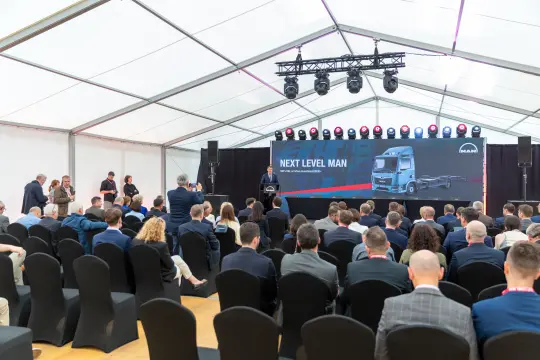 Konferencja z prezentacją nowego modelu ciężarówki MAN w namiocie z uczestnikami.
