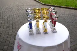 Puchary w różnych kolorach ustawione na białym obrusie.