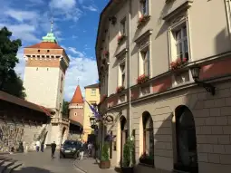 Urokliwa uliczka z zabytkowymi budynkami i wieżą obronną.