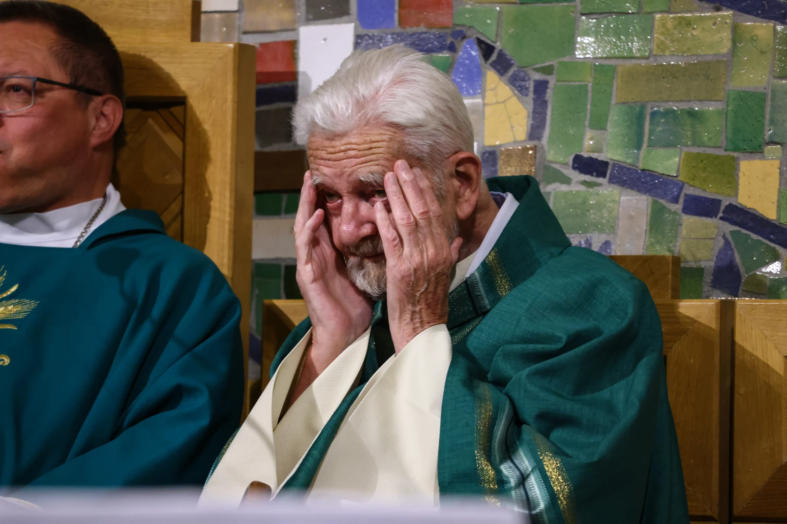 Starszy mężczyzna w szatach liturgicznych, z rękami na twarzy, wyraża emocje.  Autor: Bogusław Świerzowski