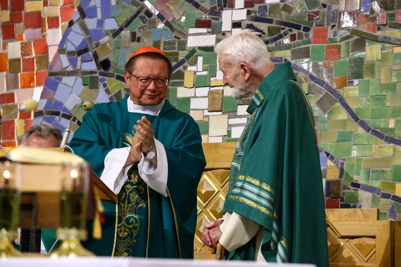 Duchowni w trakcie ceremonii religijnej w kolorowej scenerii mozaiki.  Autor: Bogusław Świerzowski